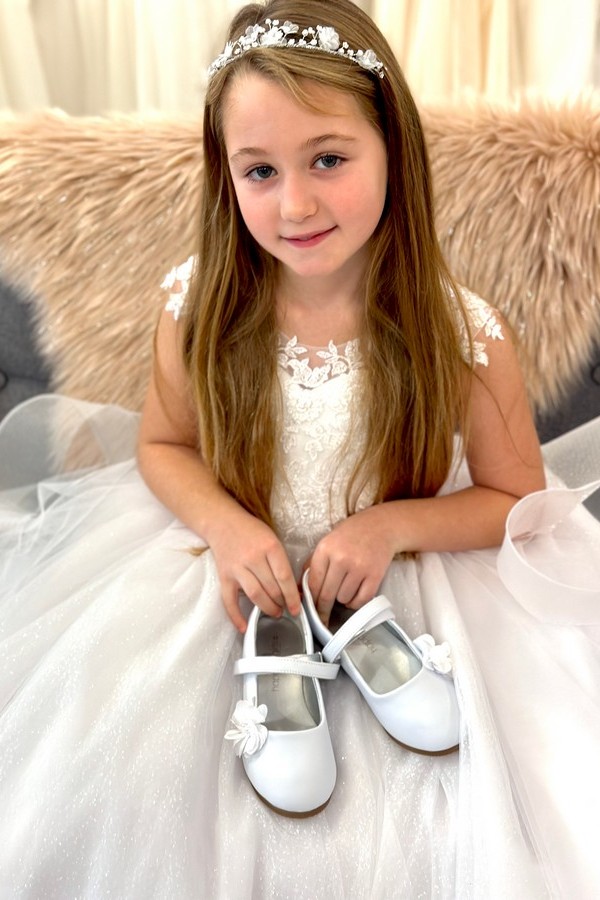 Kommunionkind mit Schuhen 9 Must-Have Accessoires für das perfekte Kommunionkleid