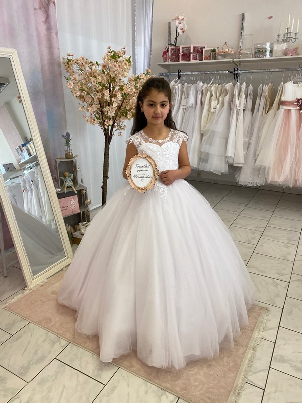 Mädchen in Kommunionkleid pompös