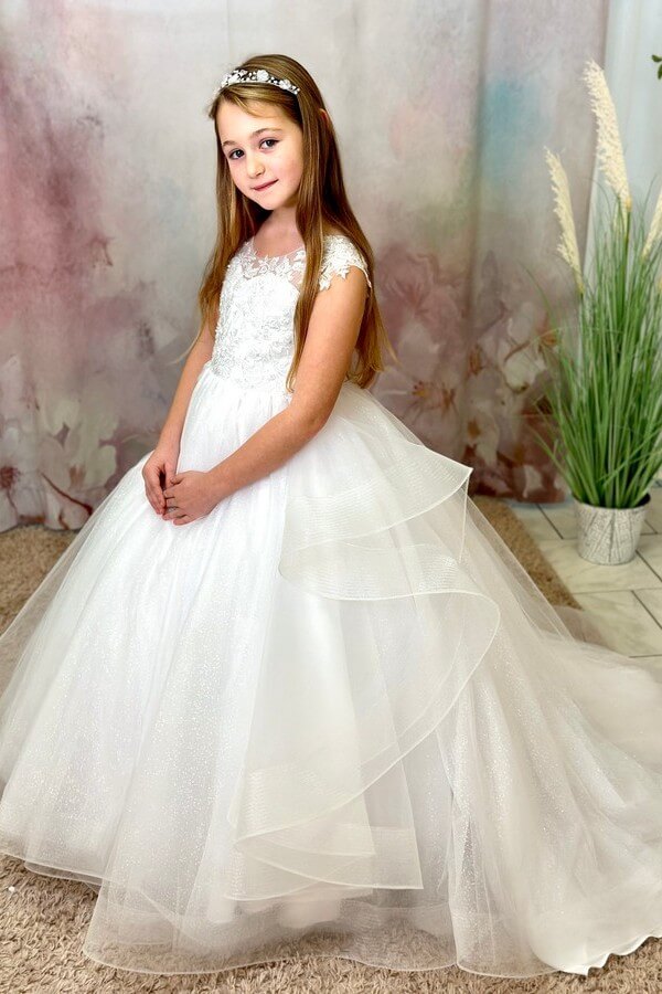 a girl in a white dress perfektes-kommunionkleid-pompoes-vs-schlicht Perfektes Kommunionkleid