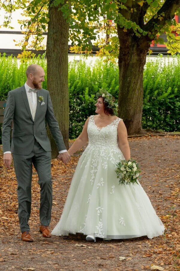 Curvybraut in grünem Brautkleid und Mann