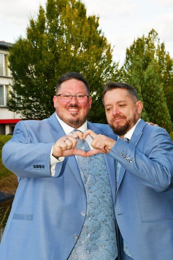Homosexuelles Hochzeitspaar in gleichen Anzügen