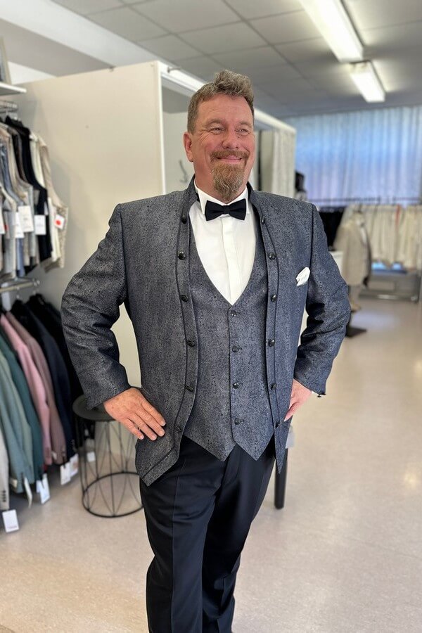 Bräutigam in großer Größe trägt eleganten, blau gemusterten Tziacco-Anzug mit Stehkragen – festliche Herrenmode bei Biancas Brautmoden