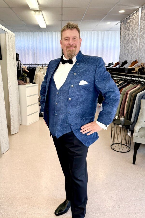 Bräutigam in großer Größe trägt eleganten, blau gemusterten Tziacco-Anzug mit Stehkragen – festliche Herrenmode bei Biancas Brautmoden