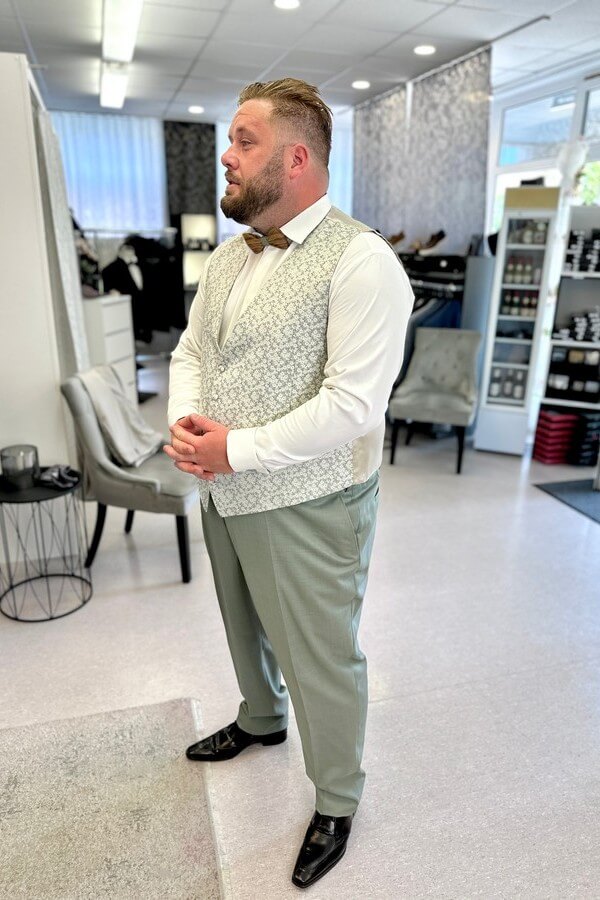 Bräutigam in großer Größe trägt eleganten grünen Hochzeitsanzug von Wilvorst mit Weste und Fliege – stilvolle Anzüge bis Größe 7XL bei Biancas Brautmoden