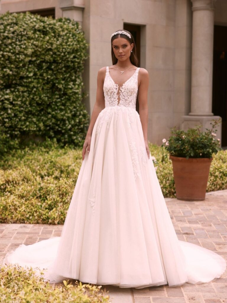 Brautkleid mit Spitze und tiefem V-Ausschnitt, Bianco Evento – romantisches A-Linien-Kleid mit Schleppe und zartem Tüllschleier, erhältlich bei Bianca’s Brautmoden.