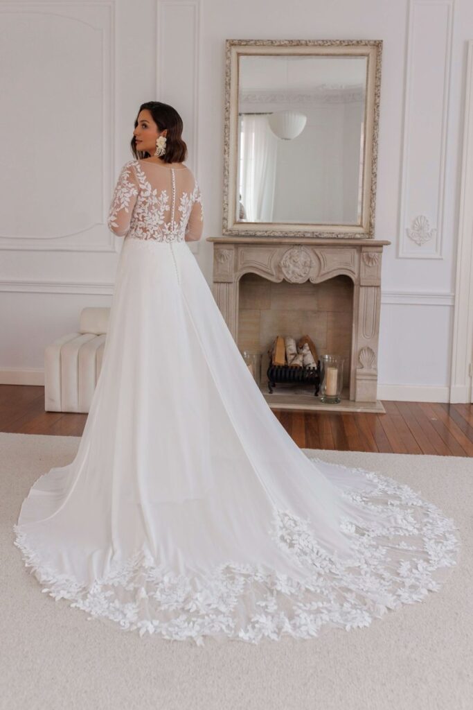 Brautkleid 2026 mit transparenter Rückenpartie und bestickter Schleppe aus Spitze von Bianca’s Brautmoden