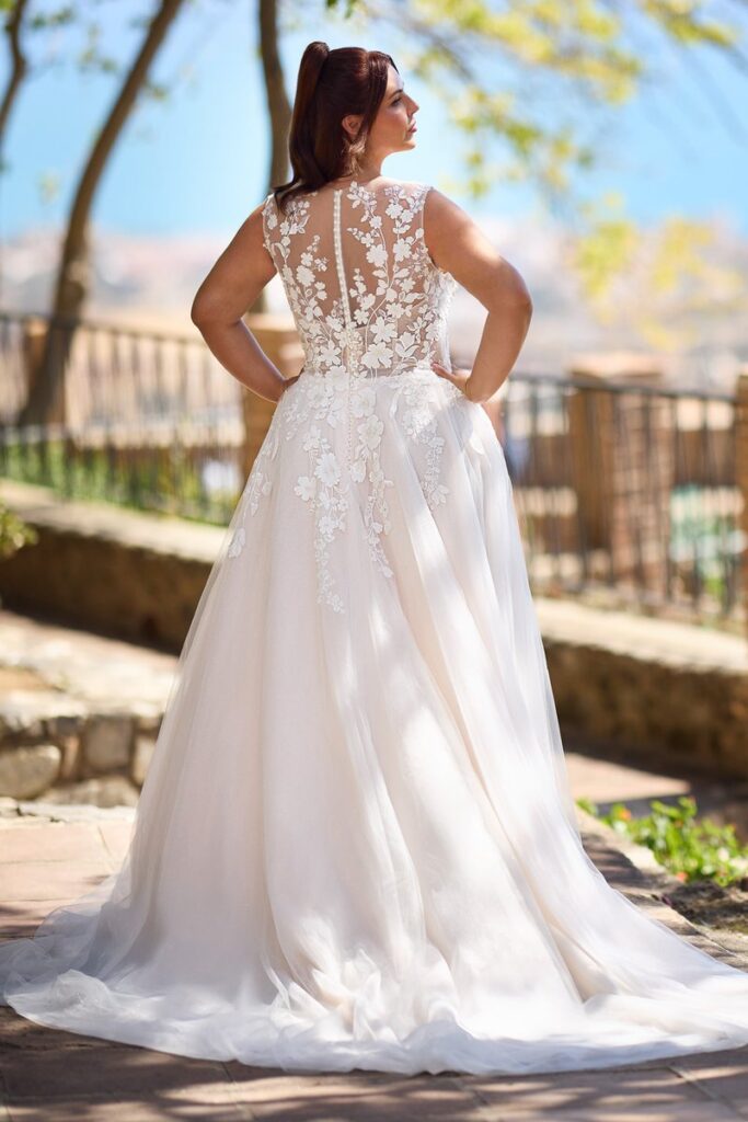 Curvy Brautkleid 2026 mit transparenter Rückenpartie aus Spitze, floraler Stickerei und fließendem Tüllrock von Bianca’s Brautmoden