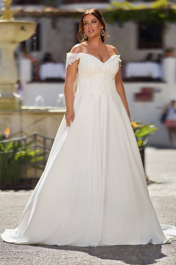 Curvybrautkleid mit Carmenträgern aus Satin von Tres Chic 2026.