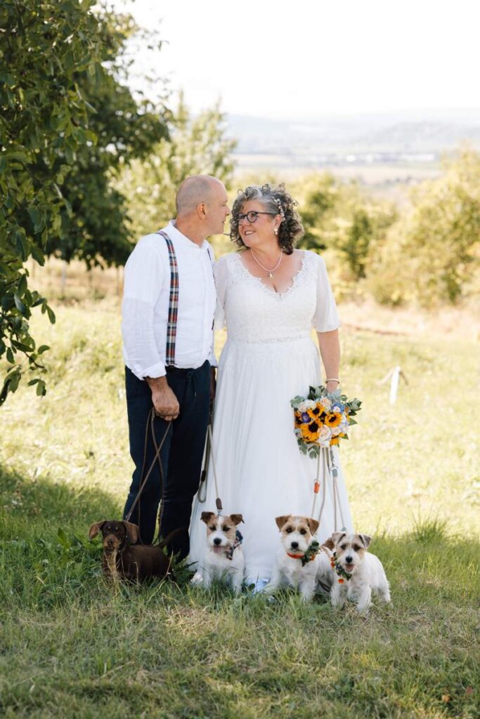 Curvy Braut im Spitzenkleid mit Blumenstrauß und Bräutigam beim Standesamt – Bianca’s Brautmoden, Spezialist für Curvybrautmode Rheinland-Pfalz.